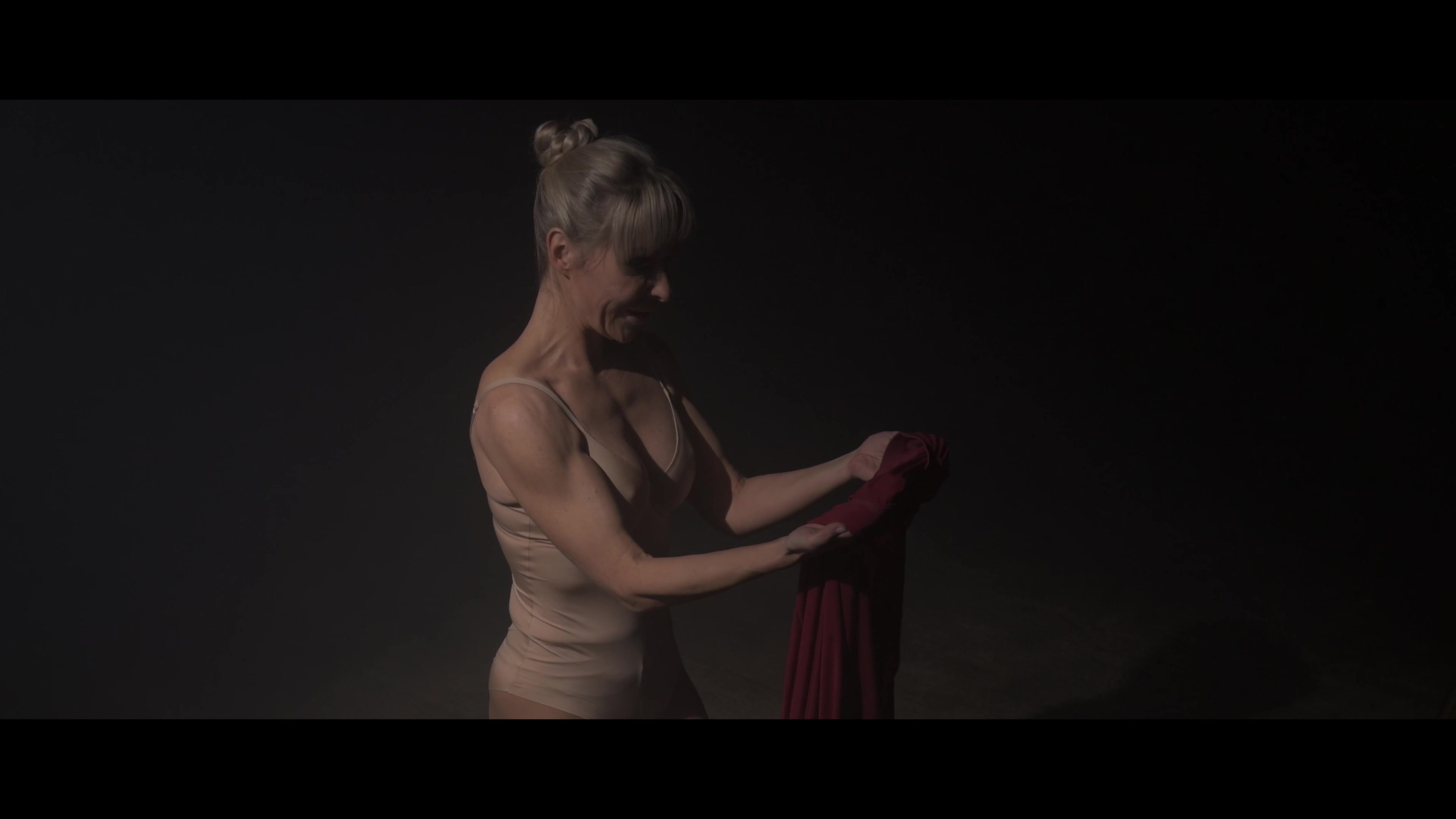 Julia Romanovich holding a folded red dress